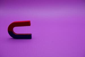 Horseshoe magnet isolated on purple background photo