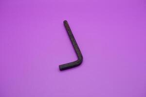 Allen key isolated purple background. a black L key. photo