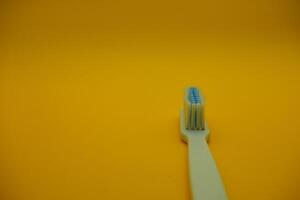 white toothbrush isolated on dark yellow background photo