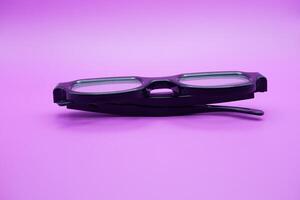 sunglasses isolated on purple background. sunglasses with curved frames and transparent glass. photo