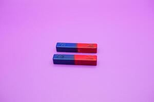 two bar magnets isolated on a purple background photo