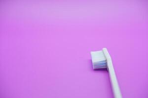 White toothbrush isolated on purple background photo