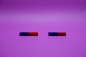 two bar magnets isolated on a purple background photo