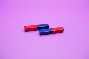 two bar magnets isolated on a purple background photo