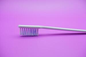 White toothbrush isolated on purple background photo