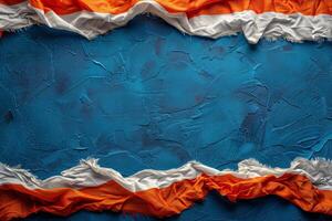 Orange, Teal, and White Fabric Draped on Blue Background photo