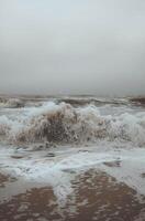 Large Ocean Waves Crashing on a Beach in Overcast Weather photo