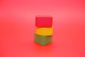 colorful wooden toys isolated red background. wooden toys shaped like triangles, squares and circles. photo