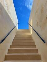 White Stone Staircase Leading Up to a Blue Sky View in a Modern Building photo
