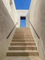 White Stone Staircase Leading Up to a Blue Sky View in a Modern Building photo