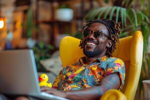 Smiling Man Using Laptop in Yellow Chair photo