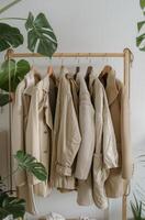 A Row of Cream Knit Sweaters Hanging on a Wooden Rail photo