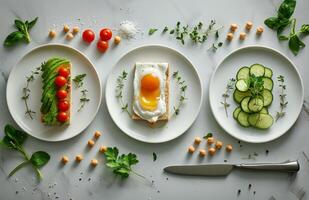 Fried Egg With Green Sprouts, Avocado, Tomatoes, Cucumber, and Chickpeas on White Plates photo