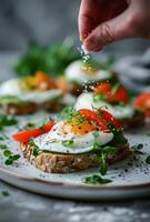 Hand Sprinkling Salt on Poached Egg Avocado Toast With Smoked Salmon and Dill photo