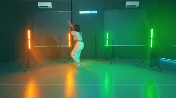 Person dancing in a studio with colorful lights video