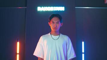 Person posing in front of neon 'Dance Hui' sign with colorful lights video
