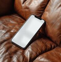 Modern Smartphone Laying on a Brown Leather Couch photo