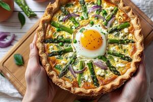 Delicious Asparagus, Red Onion, and Egg Quiche on Rustic Wooden Table photo