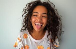 Young Woman With Curly Hair Smiles and Sticks Out Tongue photo