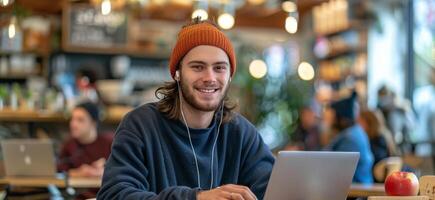 Smiling Man Working on Laptop in a Cafe With a Hat photo