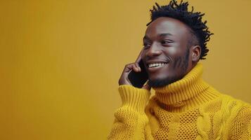Smiling Man Talking on Phone in Yellow Sweater Against Yellow Background photo