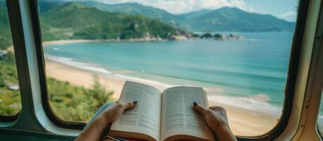 Person Reading Book on Train With Coastal View in Japan photo