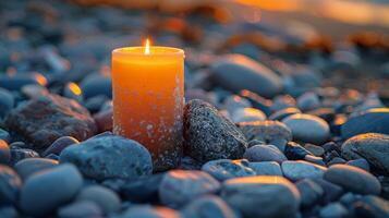 A Lit Candle on a Pebble Beach at Sunset photo