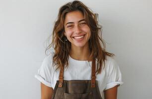 Smiling Woman Wearing an Apron Against a White Wall photo