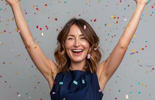 Woman Celebrates With Confetti and Raised Arms photo