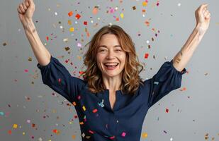 Woman Celebrates With Confetti and Raised Arms photo