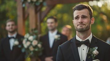 A groom weeps tears of joy as he watches his bride walk down the aisle photo