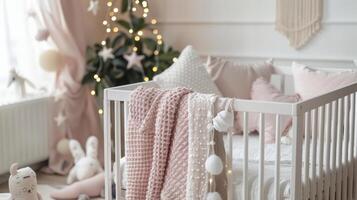 A baby crib adorned with pink blankets and pillows in a white nursery photo