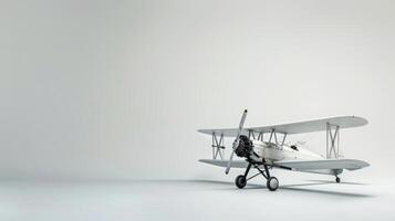 A white biplane sits on a white backdrop photo