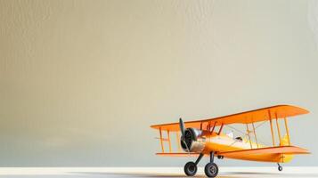 A bright orange vintage biplane model on a beige background photo