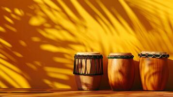 Three drums sit on a wooden surface, bathed in the golden light of the afternoon sun photo