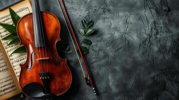 A violin rests on a sheet of music, accompanied by greenery photo