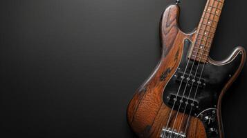 A close-up shot of a vintage bass guitar lying on a black surface photo
