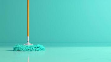 A mop rests against a turquoise wall, ready for cleaning photo