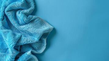 A soft blue towel sits on a blue background photo