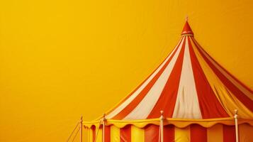 The top of a red and yellow striped tent against a yellow wall photo
