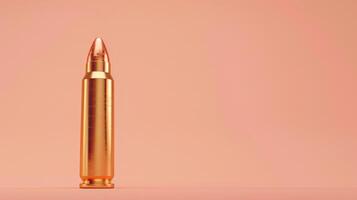 A single gold bullet stands upright against a soft peach background photo