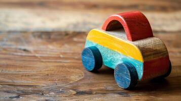 Wooden toy car painted blue, yellow, and red on rustic table photo