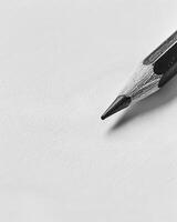 A close-up shot of a graphite pencil tip on a blank piece of paper photo