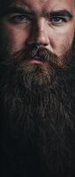 A close-up portrait of a man with a long, wavy beard photo
