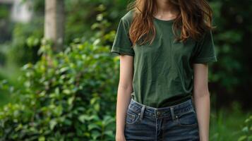 A woman wearing a green t-shirt with blank space for text against a green leafy background photo