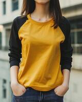 A young woman wears a mockup of a yellow and black raglan shirt photo
