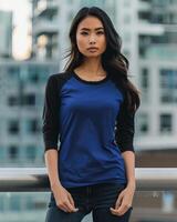 Female model wearing a blue and black raglan shirt in an urban environment photo