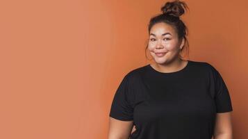 Woman wearing a black t-shirt against an orange background photo