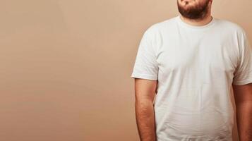 A man wearing a blank white T-shirt, standing against a muted tan background photo