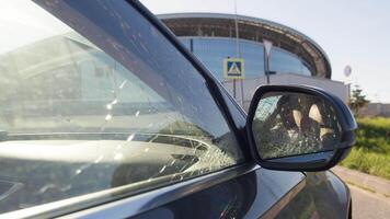 Man was involved in a car accident. He held his head and assessed the damage to his car through the side-view mirror. Close up. Slow motion video